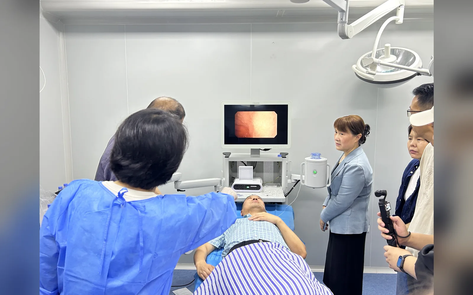Healthcare professionals conduct an AICAM examination in a clinical procedure room.